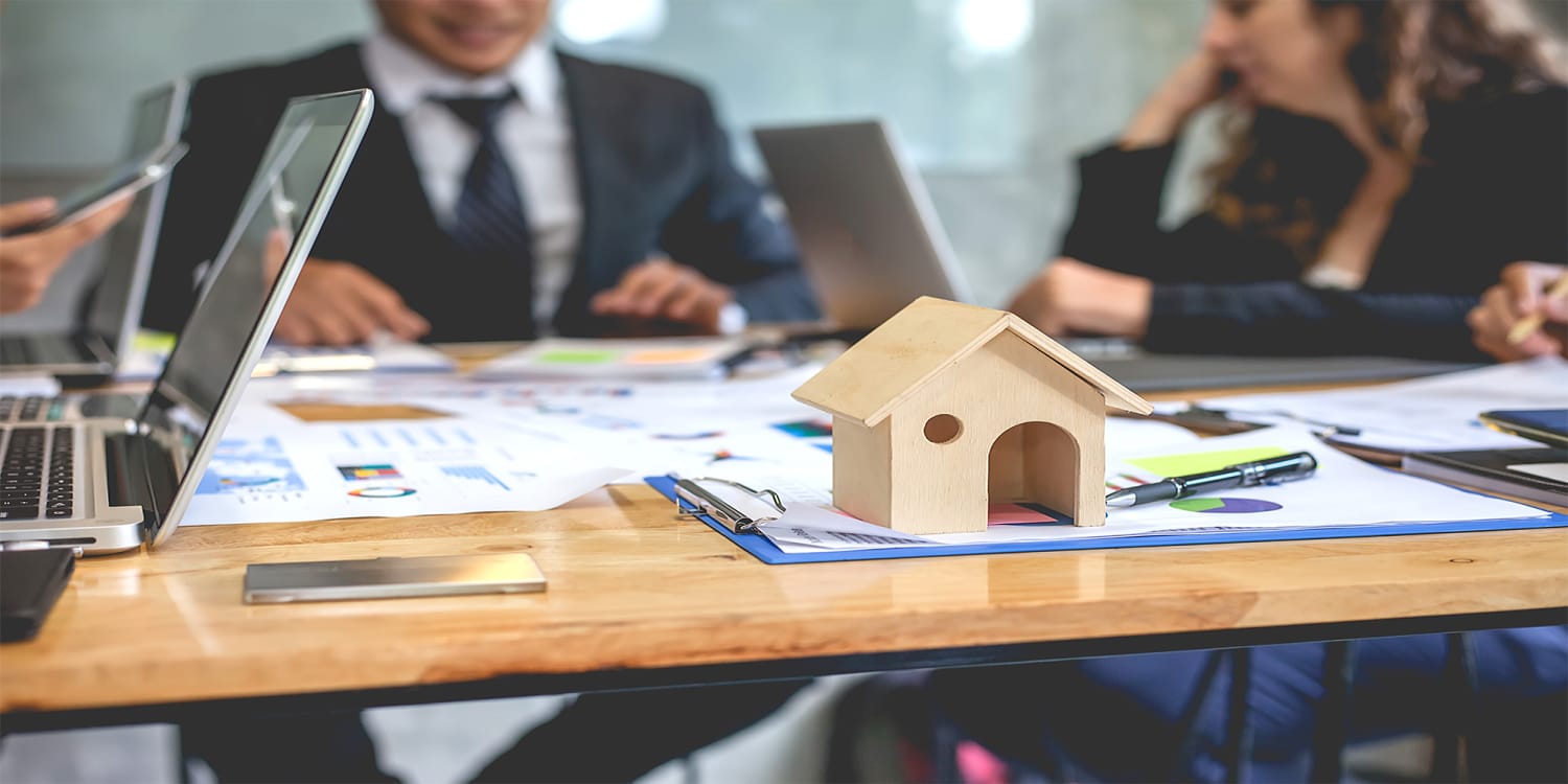 Real estate investors around table forming home buying network